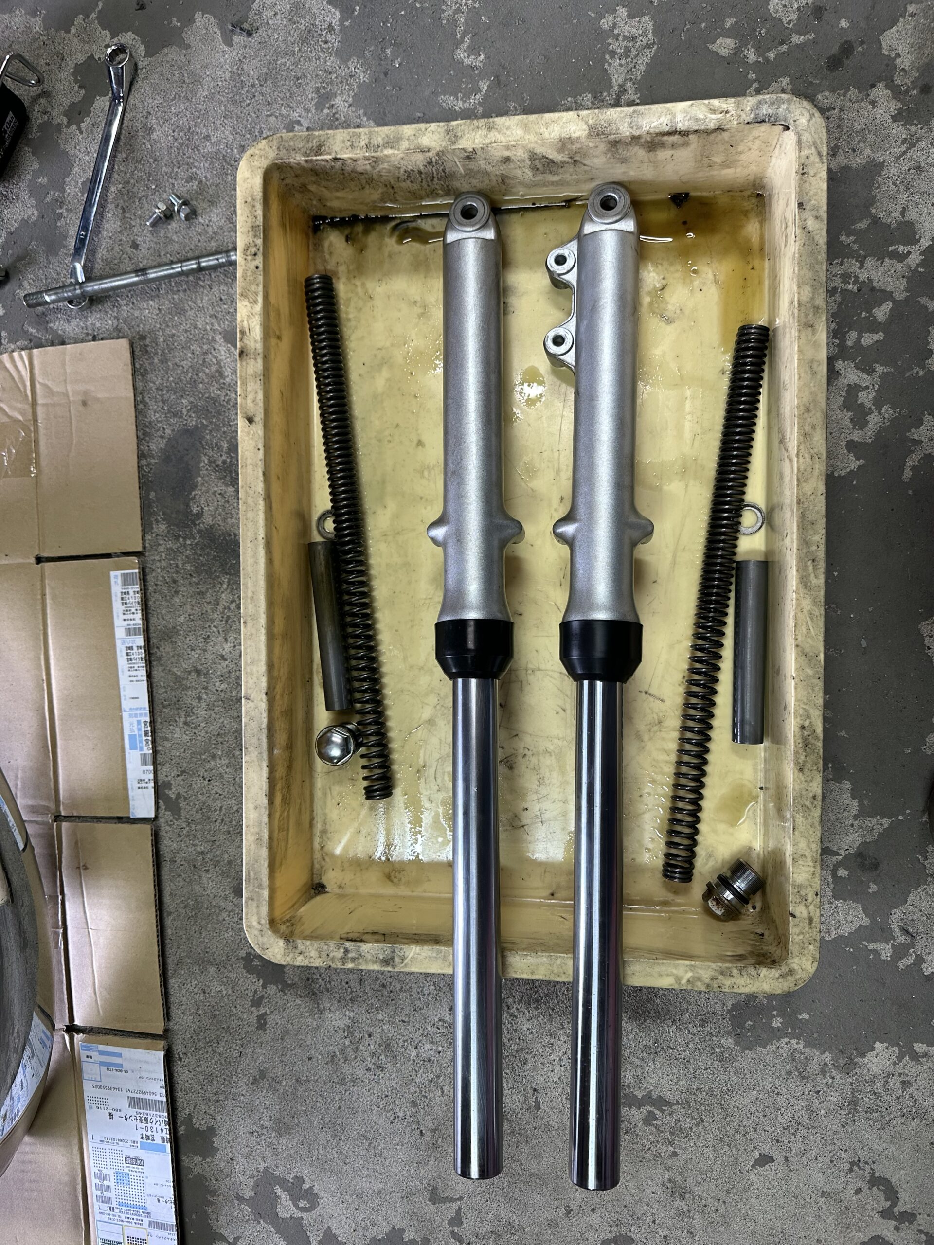 分解して並べたGN125のフロントフォークとスプリング