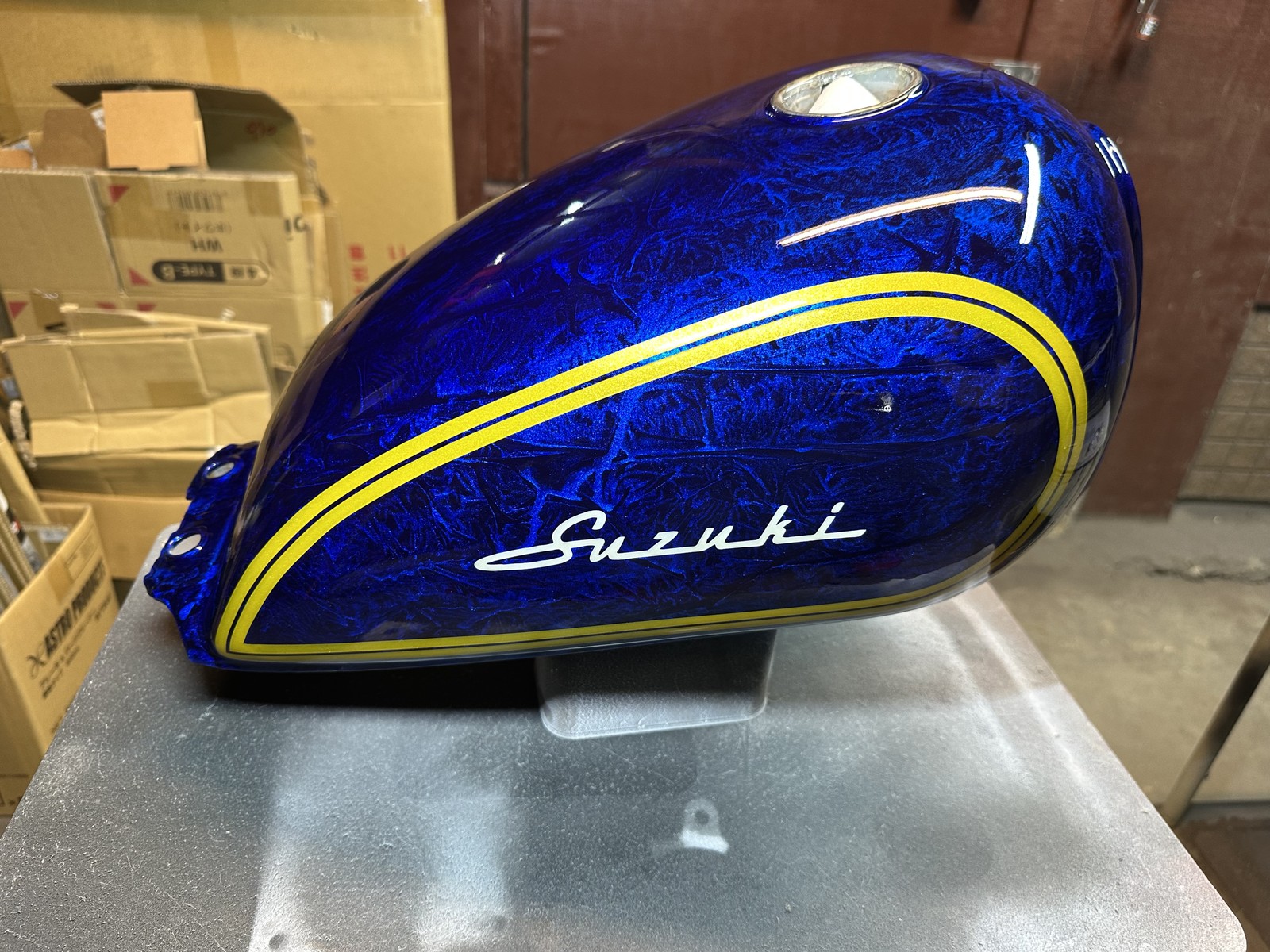 タンク側面の青いラップ模様と黄色の二重ライン、白いSuzukiの文字